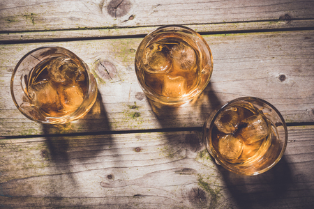 Overhead shot of glasses of whiskey on wooden tableの写真素材
