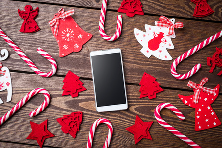 Christmas decorations with white smart phone on an old wooden tableの写真素材
