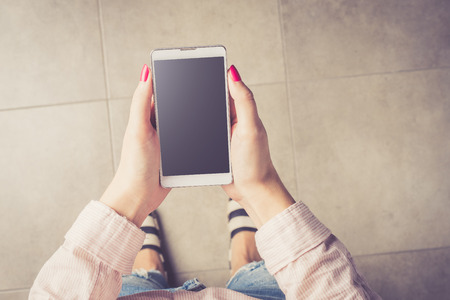 Fashionable woman holding smart phoneの写真素材