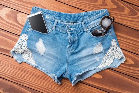 Woman's jeans shorts on wooden tableの写真素材