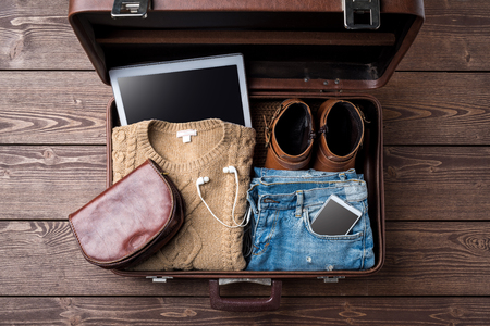 Travel preparations concept with open suitcase and woman's casual clothesの写真素材