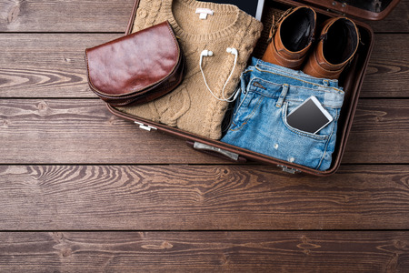 Travel preparations concept with open suitcase and woman's casual clothesの写真素材