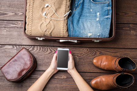 Travel preparations concept with open suitcase and woman's casual clothesの写真素材