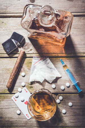 Overhead shot of hard alcohol and drugs on wooden table. addiction conceptの写真素材