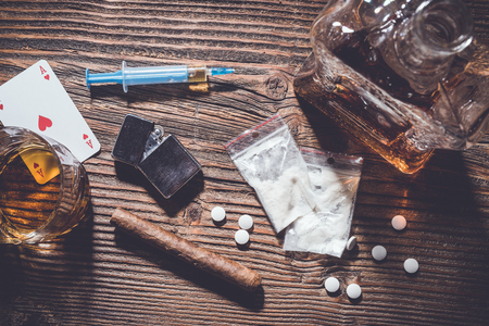 Addiction concept. Hard drugs and alcohol on wooden tableの写真素材