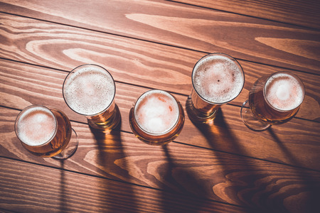 Overhead shot of beer glasses on wooden table. Close upの写真素材