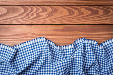 Blue checkered tablecloth on an old wooden table. Top viewの写真素材