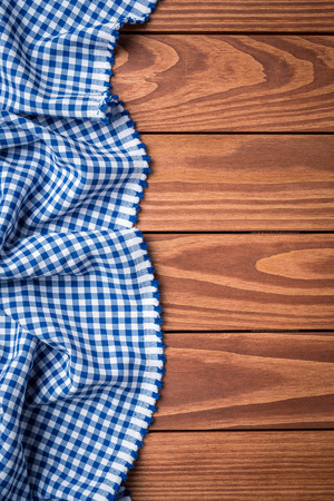 Blue checkered tablecloth on an old wooden table. Top viewの写真素材