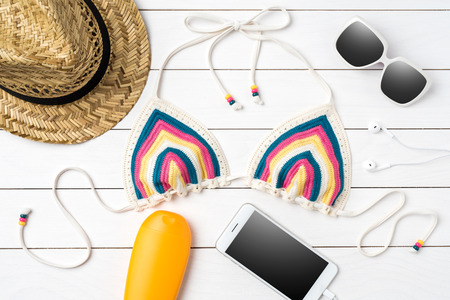 Swimsuit with beach accessories on white background