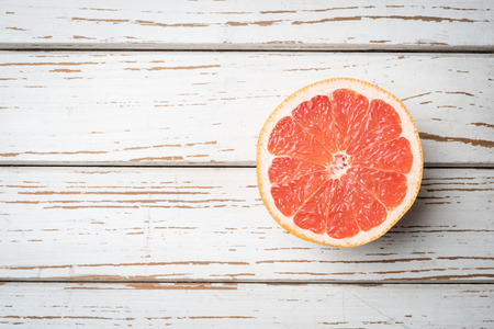 Half of red grapefruit on wooden tableの写真素材