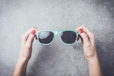 Woman holding sunglasses. Close upの写真素材