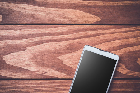 Smartphone on wooden background. Top viewの写真素材
