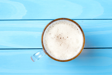 Mug of beer on a blue wooden table. Top viewの写真素材