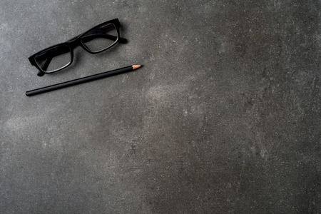 Office desktop with pencil and glasses. Top viewの写真素材