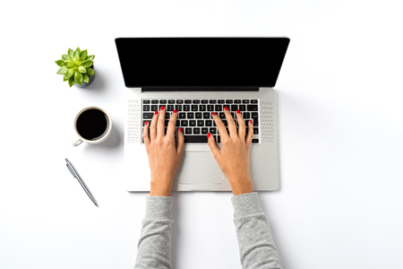 Female hands working on modern laptop. Office desktop on white backgroundの写真素材