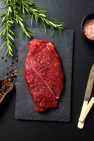 Raw beef steak on dark concrete table. Top viewの写真素材