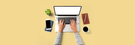 Hands with a laptop on Office desktop with copy spaceの写真素材