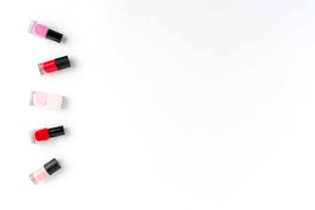 Red and pink nail polishes on white background with copyspace. Top viewの写真素材