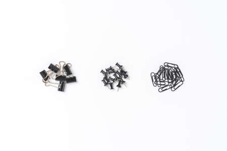 Various kinds of black paperclips and drawing pins