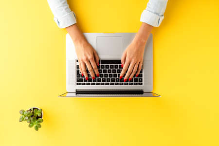 Elegant office desktop with female hands working on laptop. Business workspaceの写真素材