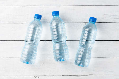Plastic bottles with water on white wooden table. Top viewの写真素材