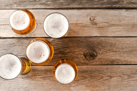 Overhead shot of beer glasses on wooden table.の写真素材