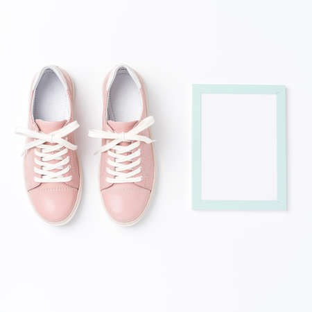 Pink sneakers and empty photo frame. Fashion backgroundの写真素材