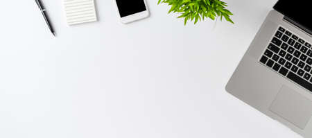 Overhead shot of laptop and business accessories on white background. Office desktop. Flat lay....
