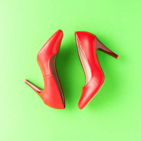 Red high heels on green background. Women's shoes. Top viewの写真素材