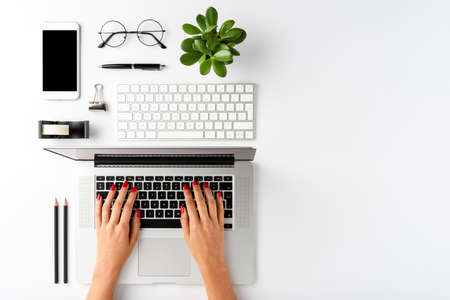 Businesswoman working on laptop. Office desktop concept with accessories and copyspace. Top view