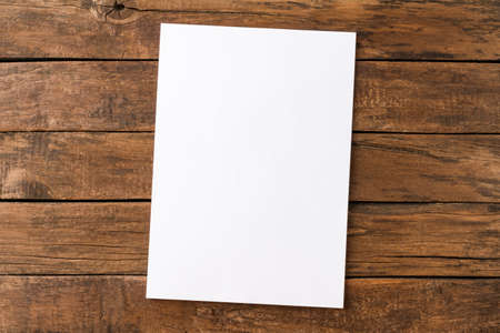 Empty white paper sheet on rustic wooden table. Top viewの写真素材