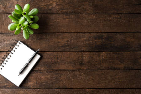 Notebook and pen on wooden background and copyspace. Office desktopの写真素材