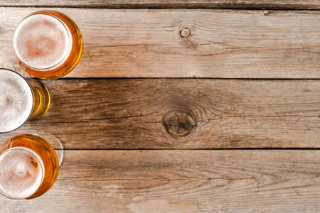 Overhead shot of beer glasses on wooden table.の写真素材