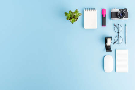 Office desktop with business accessories on blue background with copyspace. Flat layの写真素材