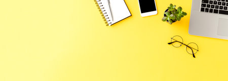Office desktop with accessories on yellow table. Business background. Bannerの写真素材