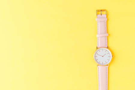 Women's wrist watch on yellow backgroundの写真素材