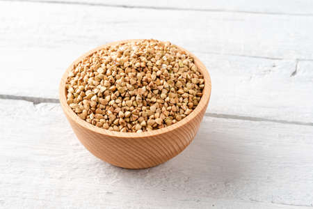 Buckwheat grains in bowl on vintage wooden tableの写真素材