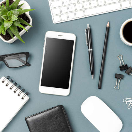 Overhead shot of office background with mobile and accessoriesの写真素材