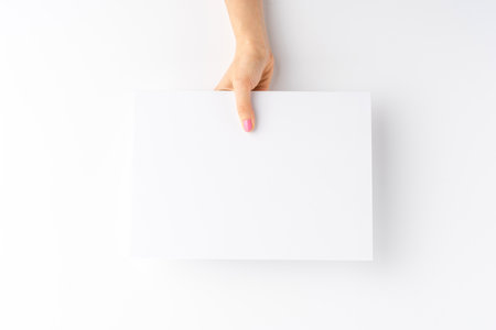 Woman's hand holding empty white paper sheet. Close upの写真素材