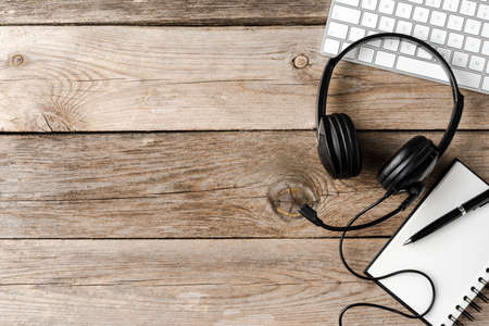 Customer service headset with office accessories on wooden desk. Top viewの写真素材