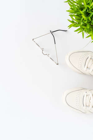 Overhead shot of outfit with sneakers and eyeglasses on white background with copyspace. Woman's lifestyle. Top viewの写真素材