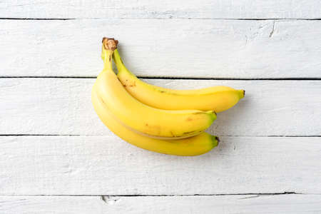 Cluster of fresh bananas on white wooden table. Close upの写真素材