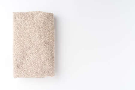 Folded beige towel isolated on white background with copyspace. Top viewの写真素材