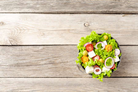 Healthy salad in bowl on wooden background. Top viewの写真素材