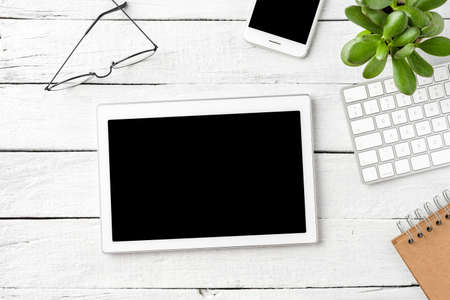 Digital tablet with empty screen on white wooden background with business accessories. Office desktopの写真素材