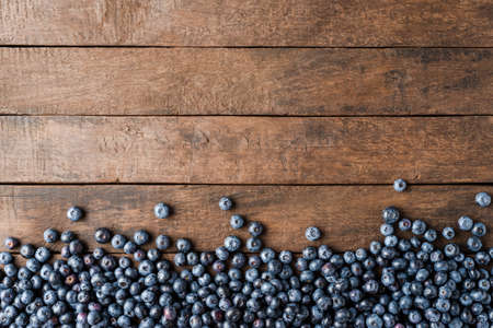 Tasty bilberries on wooden background with copyspace. Top view