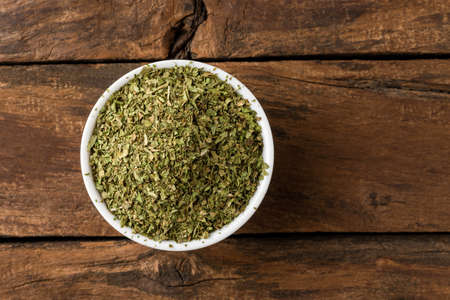 Lovage leaves in bowl on rustic wooden table. Top viewの写真素材