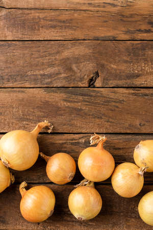 Fresh onion bulbs on rustic wooden table with copyspace. Top viewの写真素材