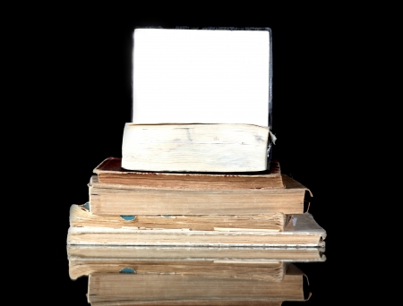 Stack of old books with blank page reflected in black surfaceの写真素材