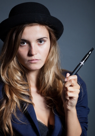 Elegant woman holding and smoking e-cigaretteの写真素材